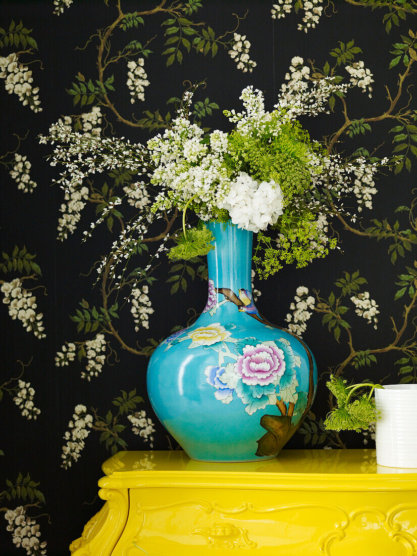 Schnittblumen in orientalischer Vase mit schwarzer Blumentapete