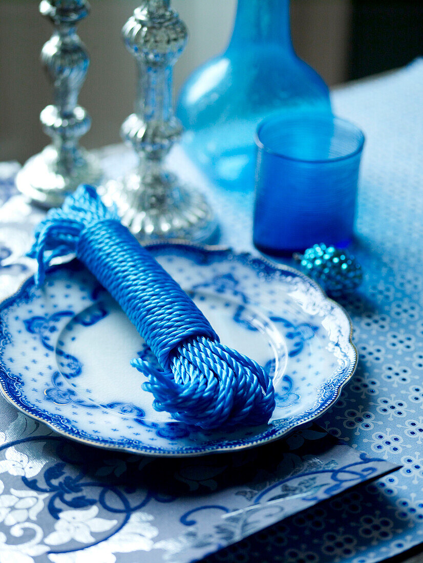 Blue string on vintage plate with silver candlesticks