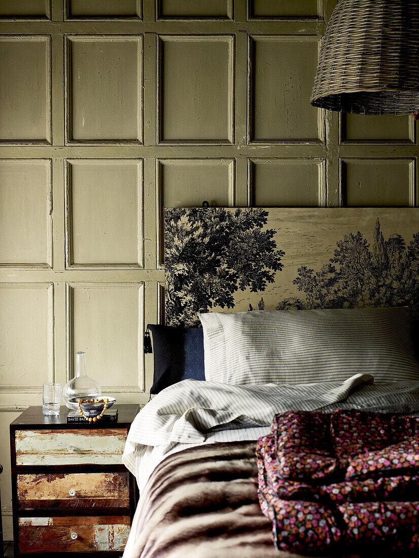 Vintage headboard with side cabinet in panelled 'filmic style' bedroom