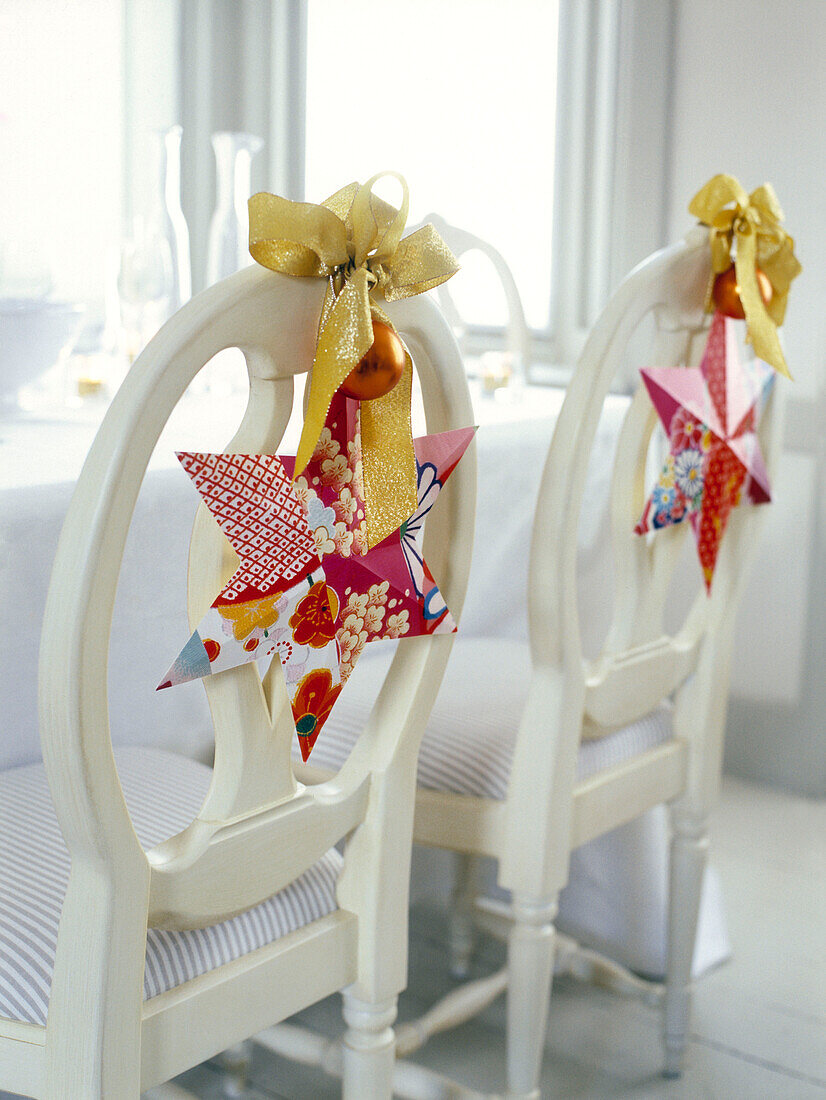 Gold ribbon and star decorations on chair backs