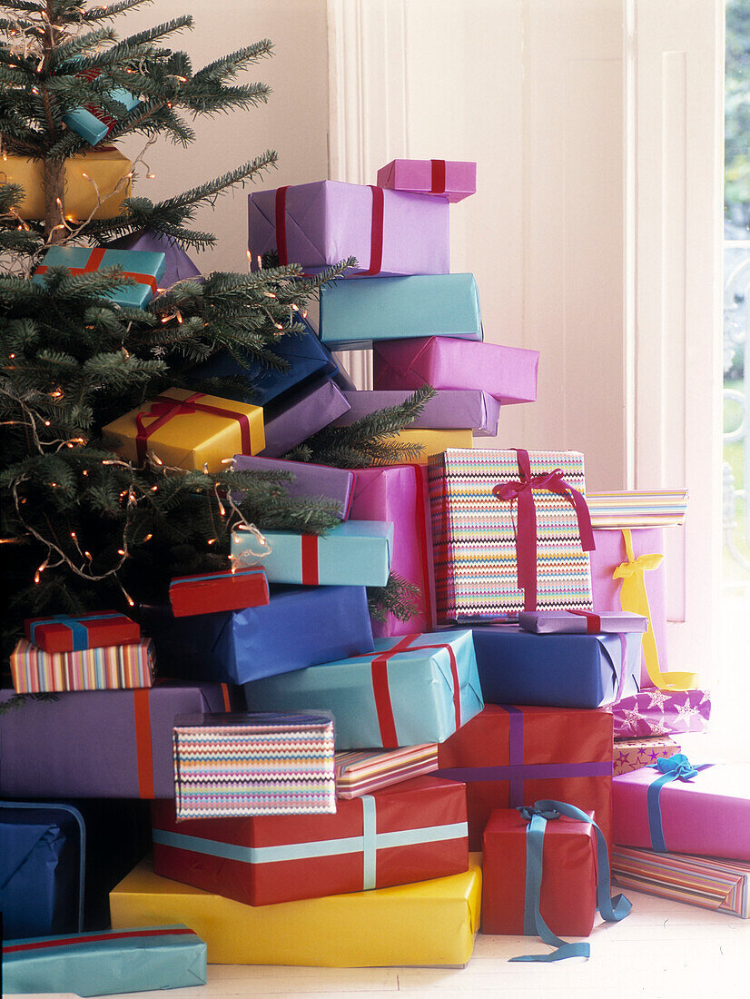 Large stack of Christmas presents under tree