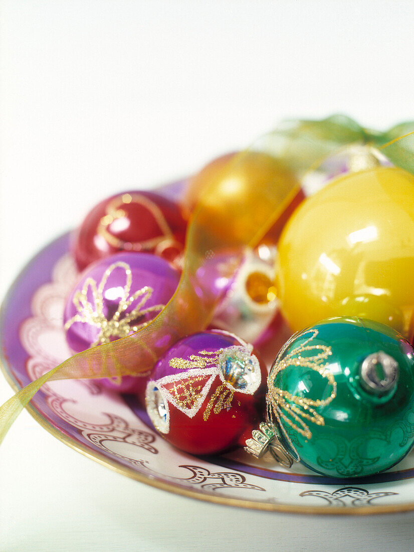 Assorted baubles on plate with gold ribbon