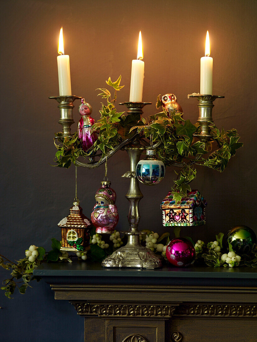 Lit candles and ivy on gold mantlepiece
