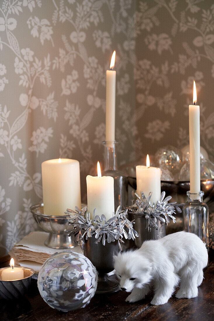 Lit candles with tinsel and snow wolf
