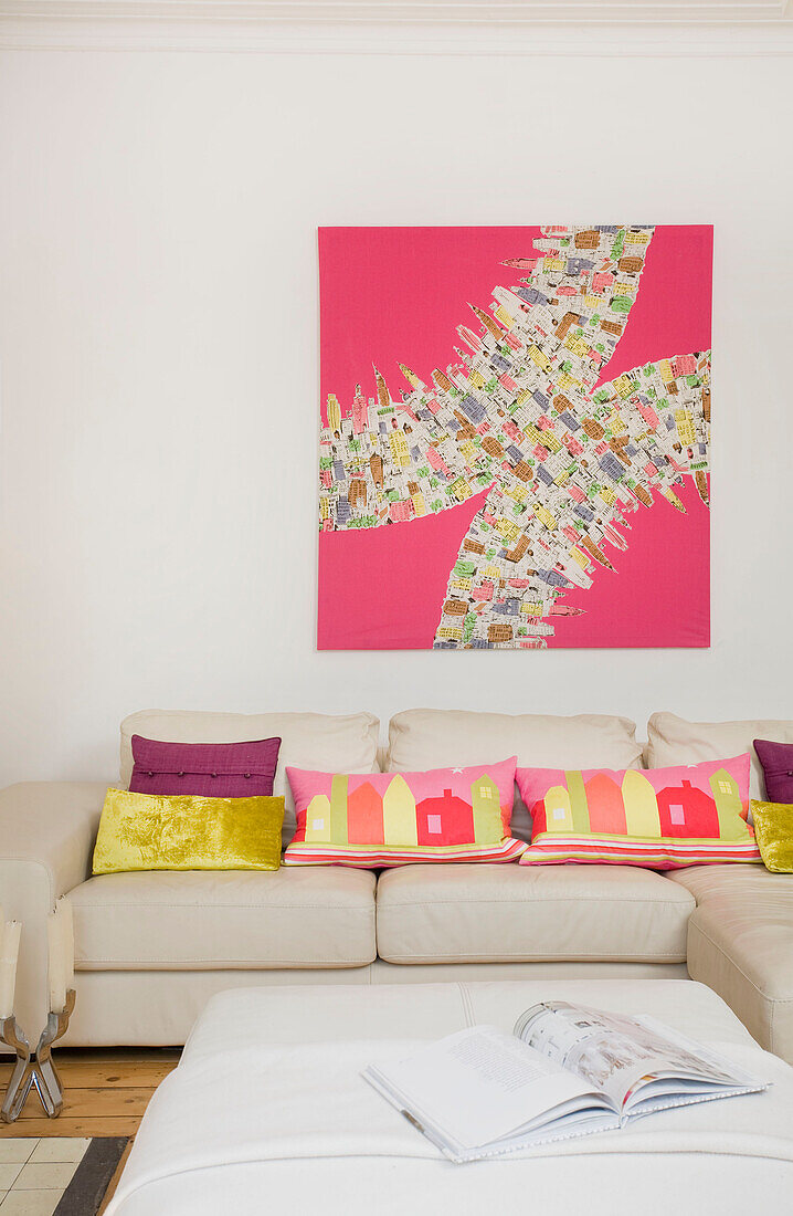 Pink canvas above white leather sofa with cushions in Manchester family home, England, UK