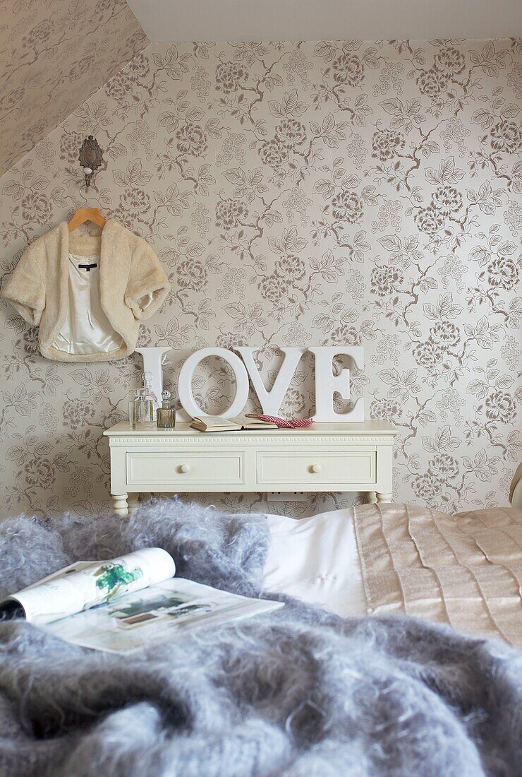 "Gemusterte Tapete und Wolldecke mit dem Wort Liebe"" im Schlafzimmer eines Hauses in Cranbrook, Kent, England, UK"""