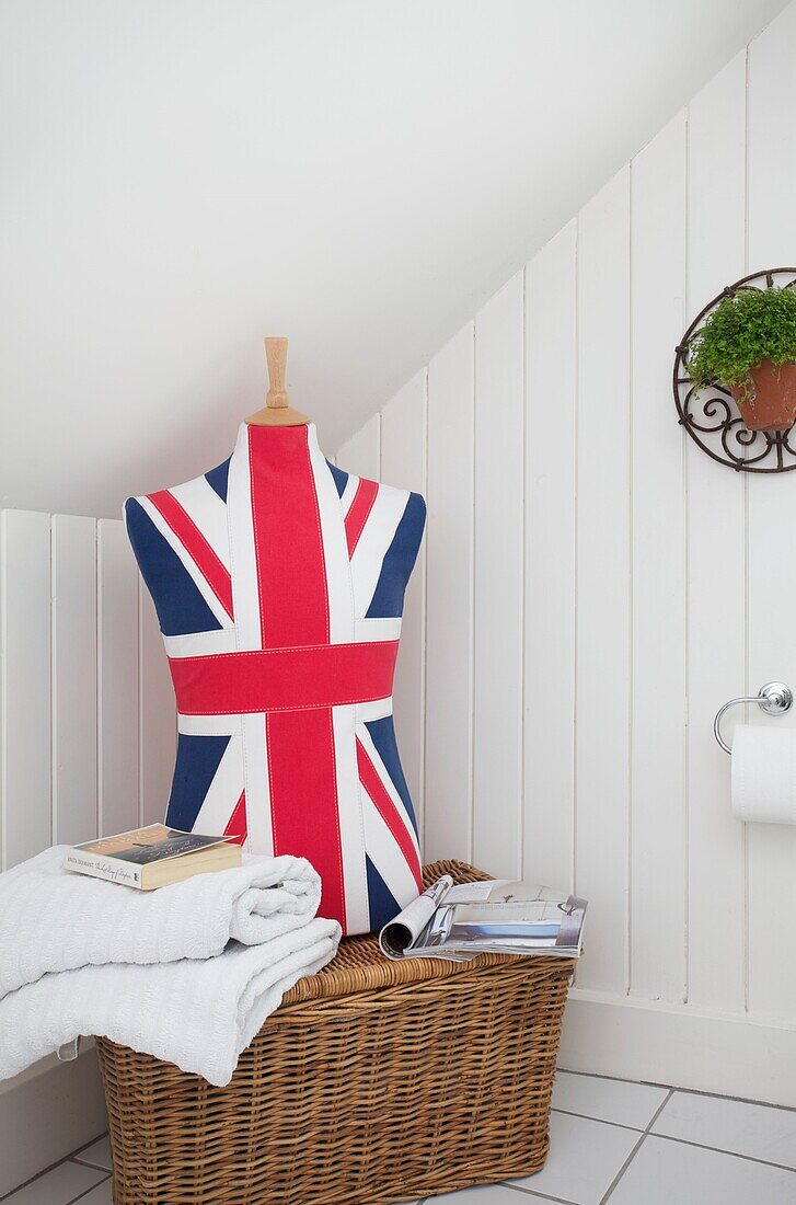 Union-Jack-Schaufensterpuppe auf einem Wäschekorb mit gefalteten Handtüchern in einem Haus in Cranbrook, Kent, England, Vereinigtes Königreich
