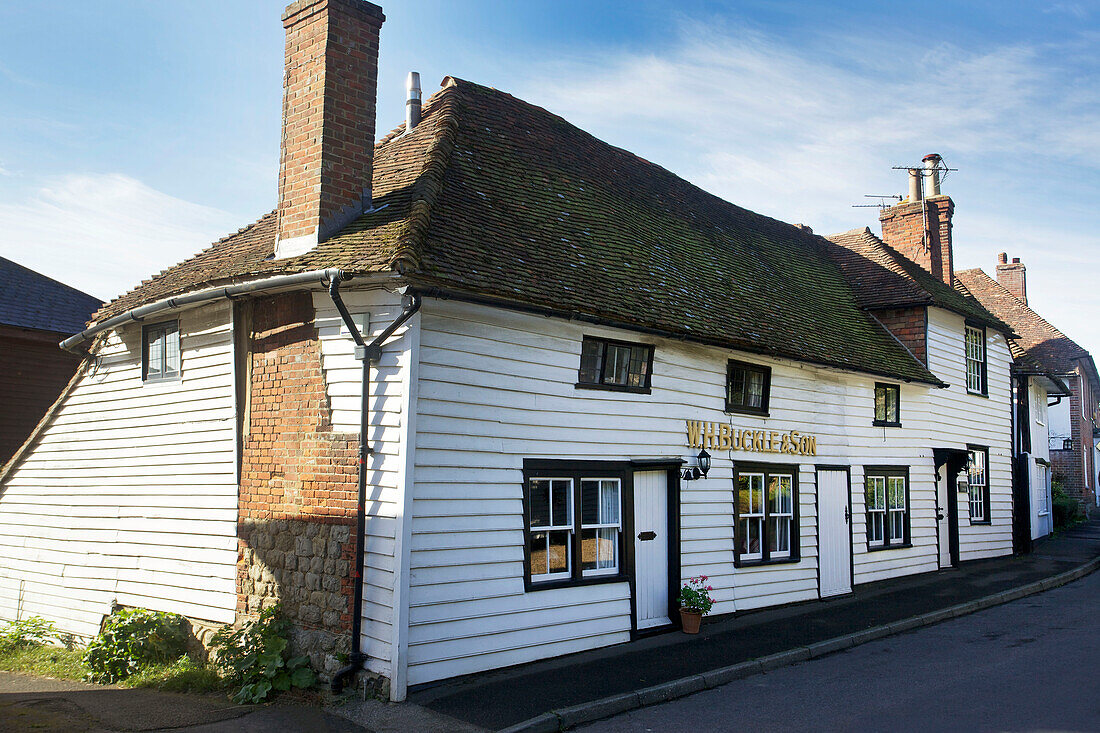 White clapboard rural house with black paintwork in Egerton, Kent, England, UK
