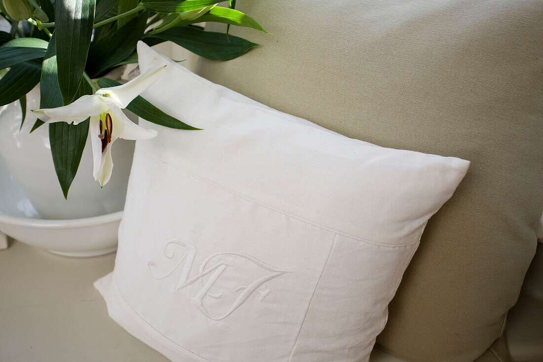 Cut lilies and monogrammed cushion in Tenterden home, Kent, England, UK