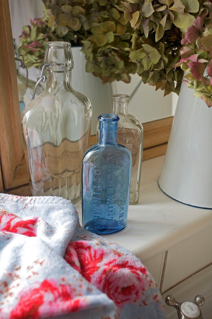 Vintage-Flaschen und getrocknete Blumen, Badezimmerdetail in einem Haus in Cranbrook, Kent, England, Vereinigtes Königreich