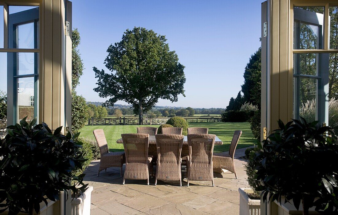 Dining area on patio viewed through conservatory doors in Grafty Green, Kent, England, UK