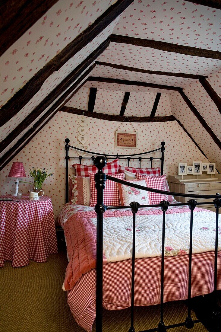 Rotes Gingham-Karo auf dem Bett im ausgebauten Dachgeschoss eines Fachwerkhauses, Grafty Green, Kent, England, UK