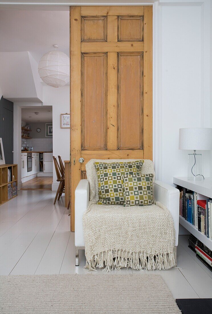 geometric patterned cushion on white leather armchair in doorway of St Leonards beach house, East Sussex, England, UK