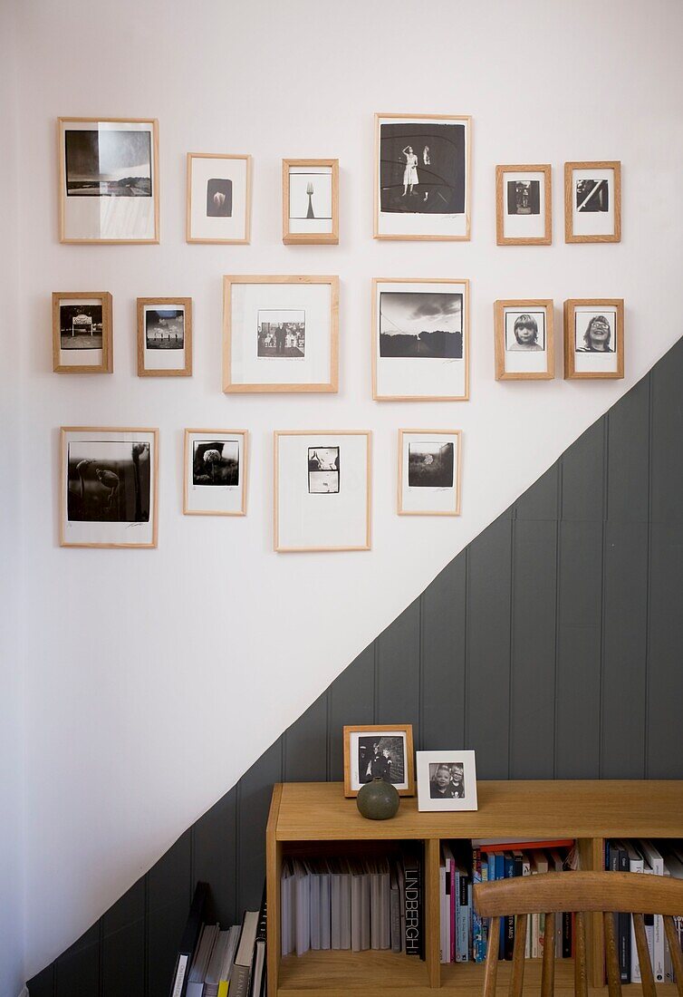 Gerahmte Schwarz-Weiß-Fotografien über grauer Vertäfelung und Anrichte in einem Strandhaus in St Leonards, East Sussex, England, UK