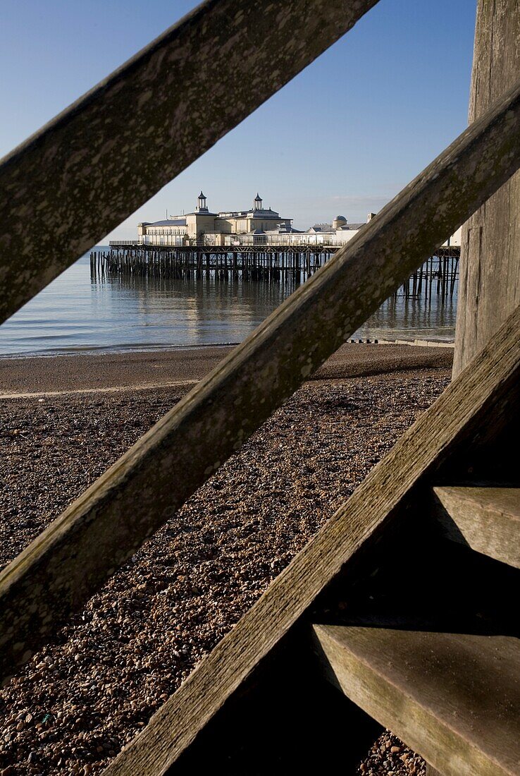 View through wooden steps to pleasure pier in St Leonards on Sea, East Sussex, England, UK