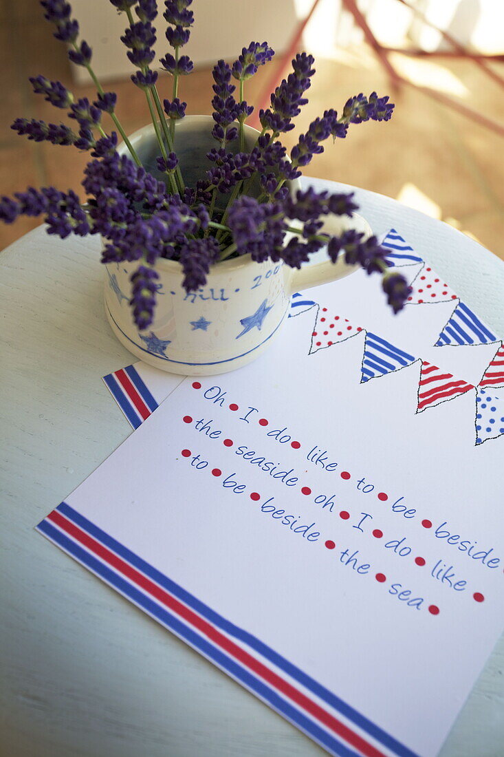 Cut flower and notepaper on tabletop in Dartmouth home, Devon, UK