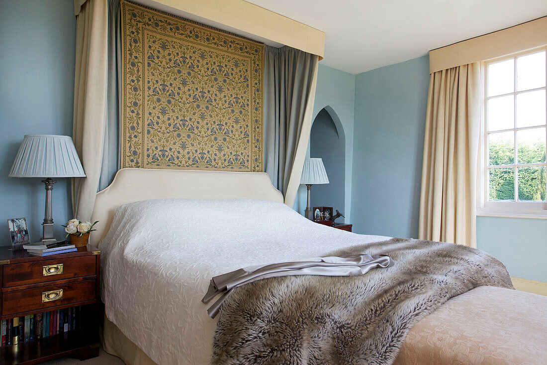 Doppelbett mit Wandbehang im hellblauen Schlafzimmer des Bauernhauses Etchingham East Sussex England UK