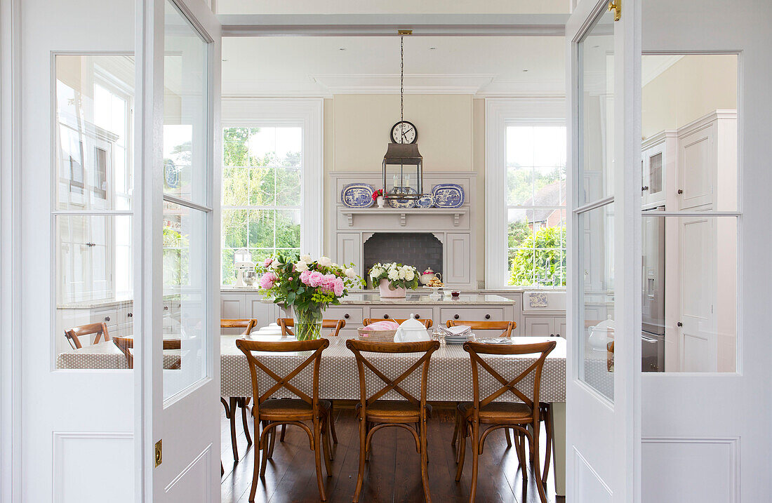 Esstisch und Stühle mit Blick durch Doppeltüren im Haus Kilndown Cranbrook Kent England UK