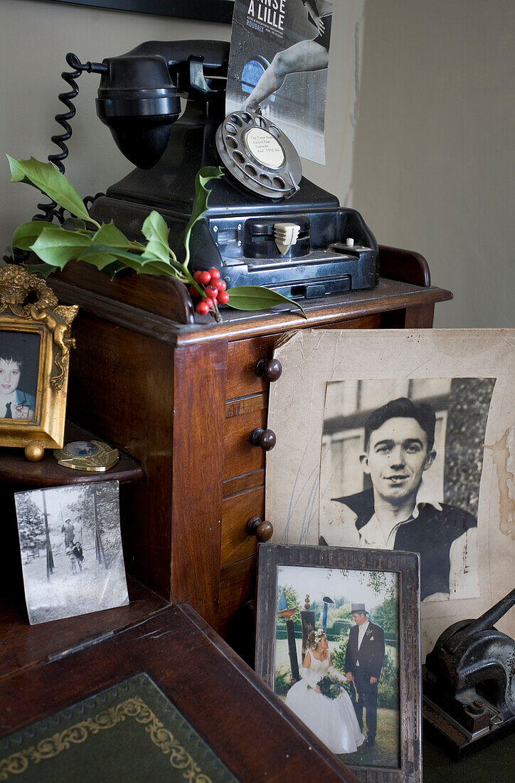 Family photographs and rotary dial telephone in Tenterden home, Kent, England, UK