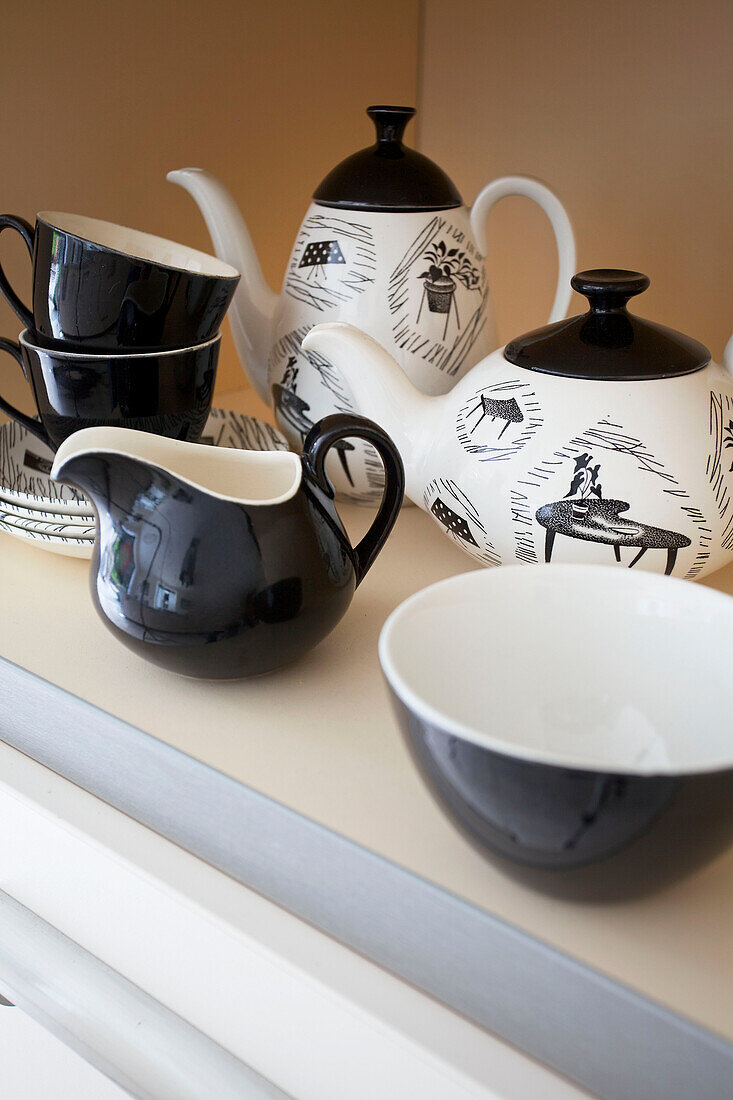 Schwarzes und weißes Teeservice auf Küchenregal in modernem Haus Bath Somerset, England, UK