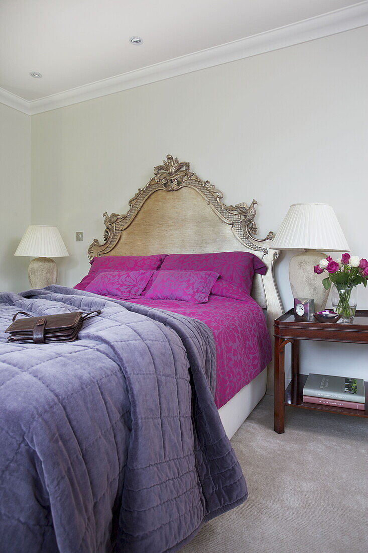 Purple and pink bed covers with matching lamps in contemporary farmhouse in Nuthurst, West Sussex, England, UK