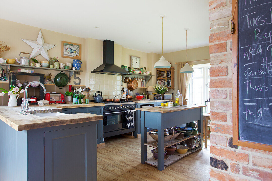 Blaue Einbauküche mit Wandtafel in einem Bauernhaus in Kent, England, UK