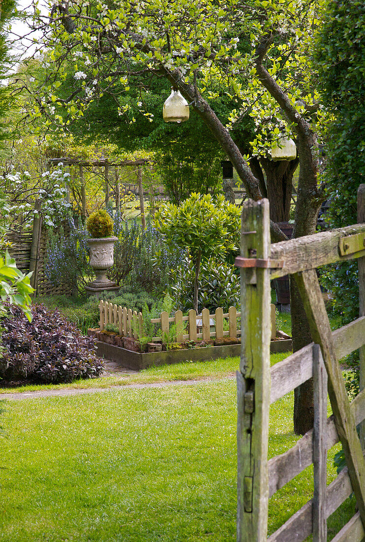 Blick durch ein Holztor in den Garten eines Hauses in Kent, England UK