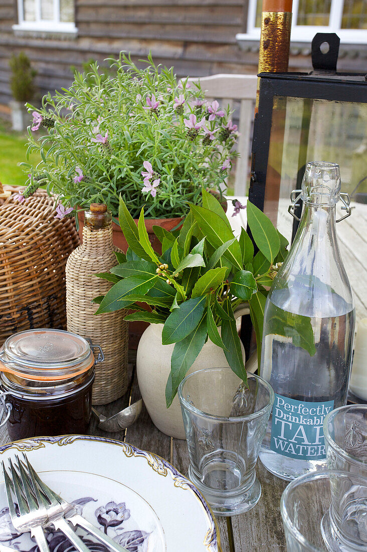 Drinking water with tableware on garden table of Kent home England UK