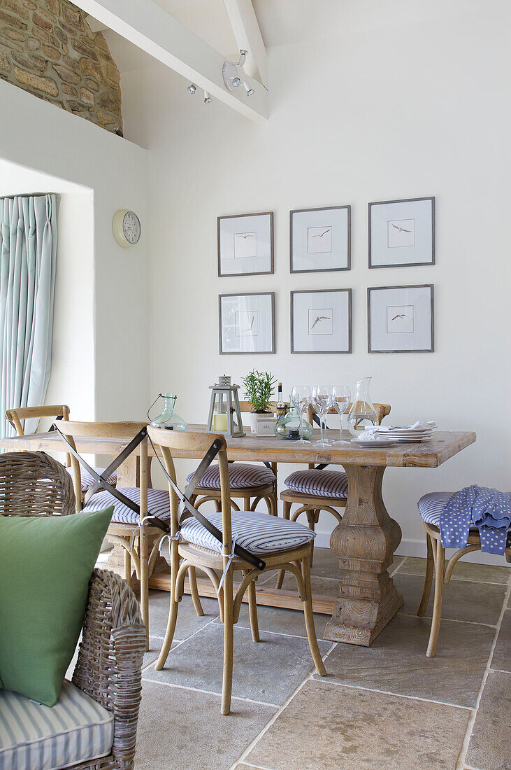 Dining table and chairs with artwork in Dorset cottage Corfe Castle England UK