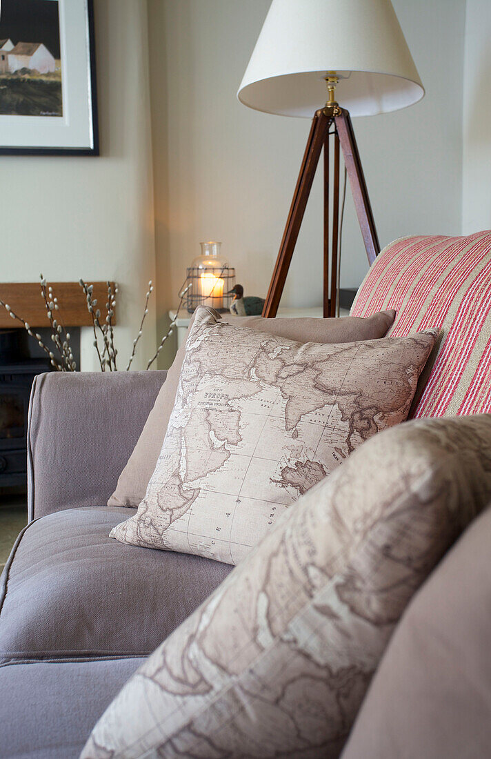 Map print cushions with tripod lamp in living room of Dorset cottage Corfe Castle England UK