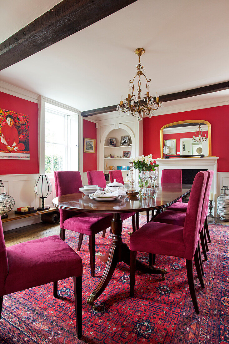 Mit rosa Samt gepolsterte Esszimmerstühle im roten Esszimmer des Hauses Bishops Sutton in Alresford Hampshire England UK