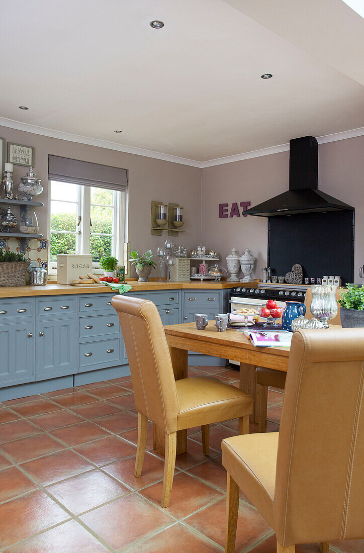 Table and chairs with blue fitted units in Staplehurst kitchen Kent England UK