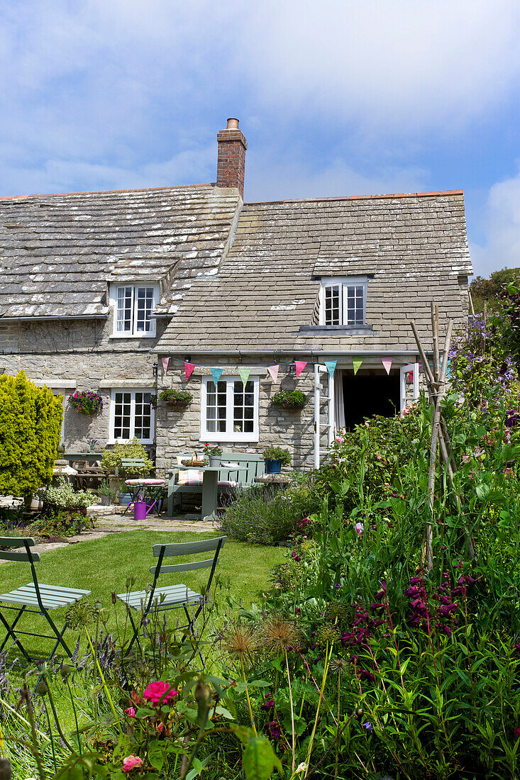 Klappstühle und Wimpel im Garten von Worth Matravers Cottage in Dorset, England, UK
