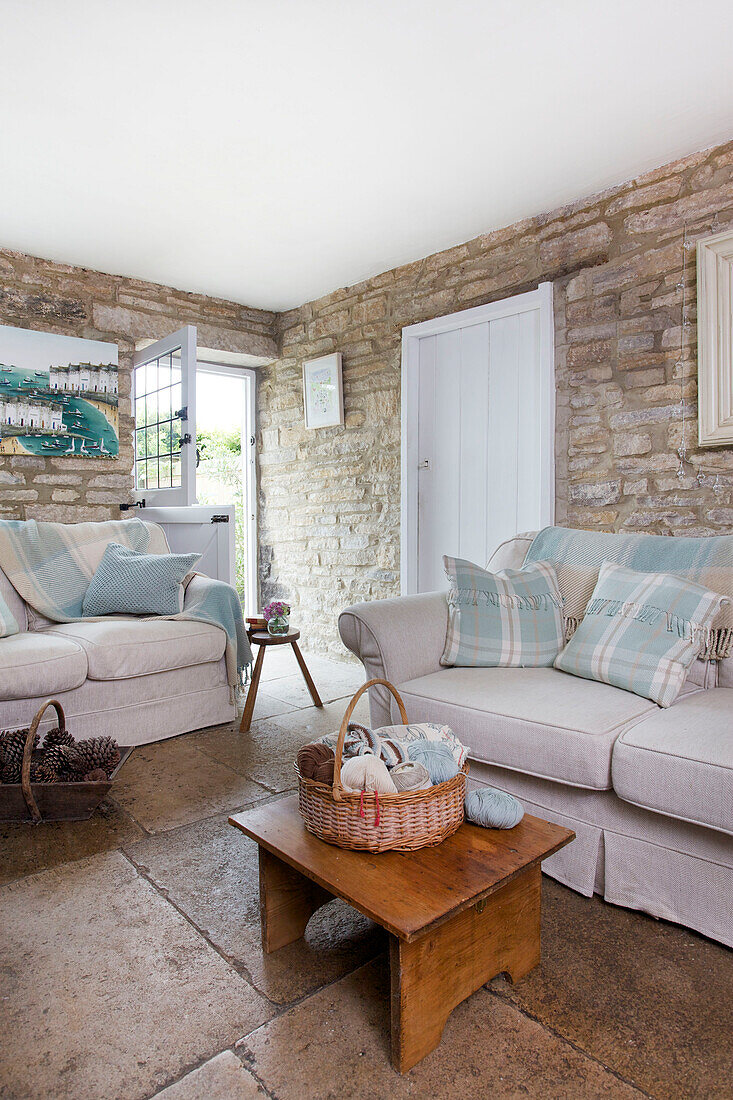 Checked cushions on sofas with wooden coffee table in living room of Worth Matravers cottage Dorset England UK