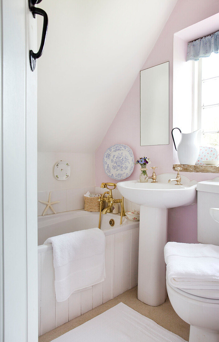 Weißes Waschbecken und Badewanne im Badezimmer von Worth Matravers Cottage in Dorset England UK