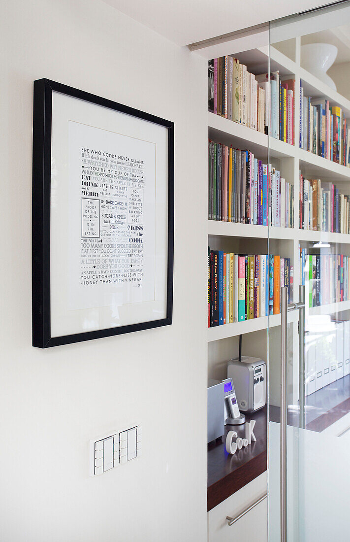 Gerahmter Text und Bücherregal in einem Haus in Wandsworth London England UK