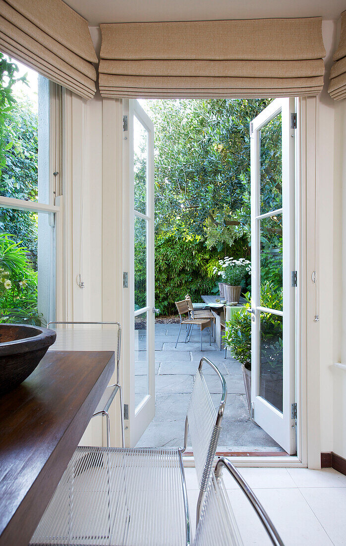 Blick durch offene Türen in den Innenhofgarten eines Hauses in Wandsworth, London, England UK