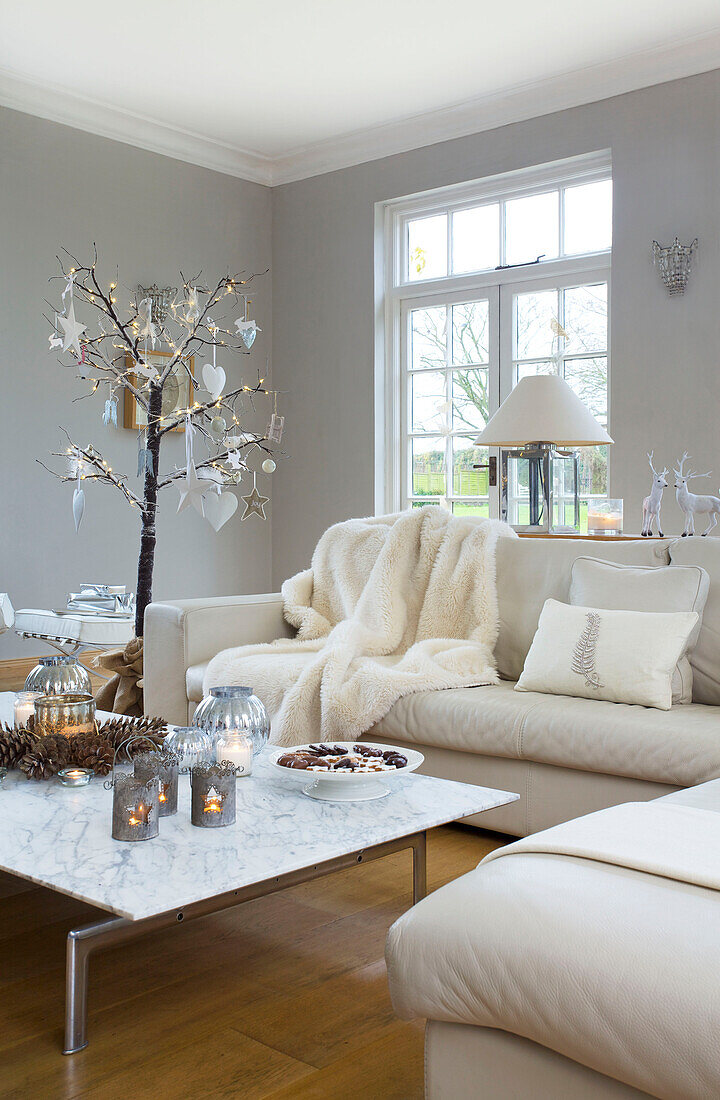 Weißes Ecksofa mit niedrigem Couchtisch im Wohnzimmer eines Hauses in Faversham, Kent England UK