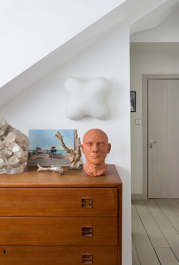 Clay bust and ornaments on wooden chest of drawers in Rye home East Sussex UK