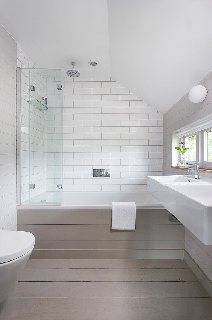 Weiß gefliestes Badezimmer mit Duschwand und Doppelwaschbecken in Rye home East Sussex UK