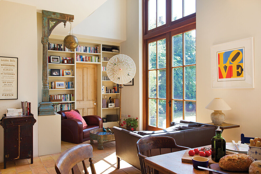Offener Wohnbereich mit Esstisch aus Holz und Glastüren in einem Haus in Hackney, London, England, UK