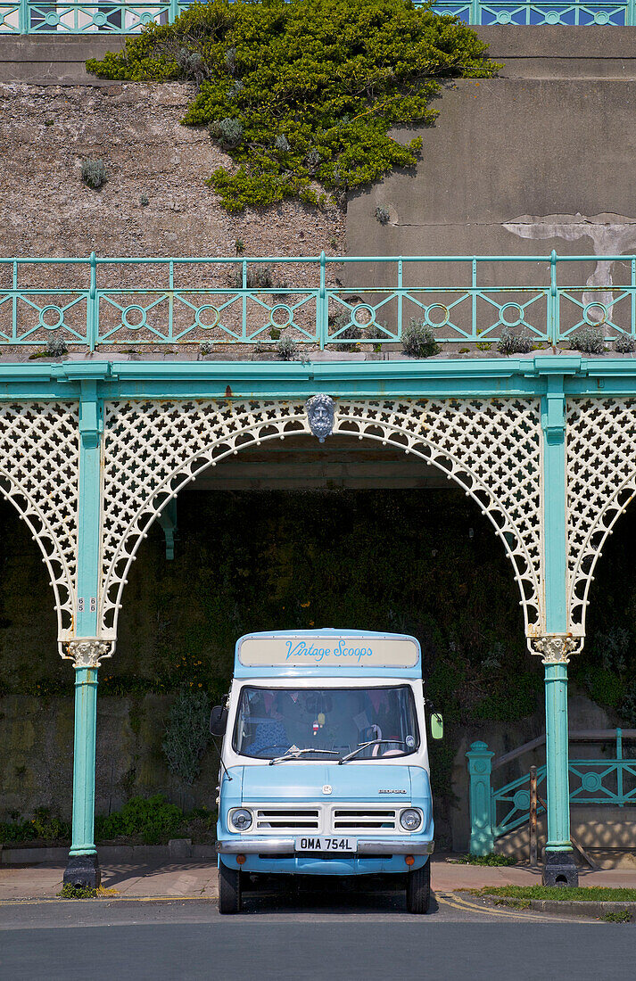 Blue ice cream van parked under wrought iron promenade Brighton Sussex England UK