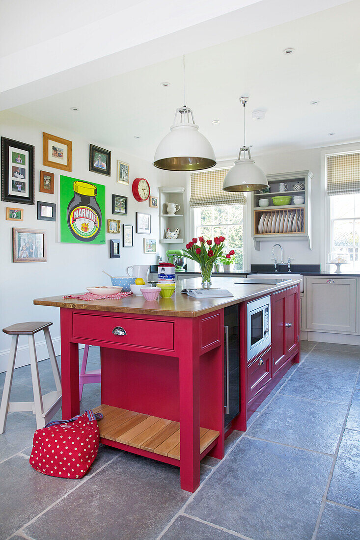 Hellrosa Kücheninsel mit Fliesenboden und Kunstwerken in einem Haus in Woodchurch, Kent, England