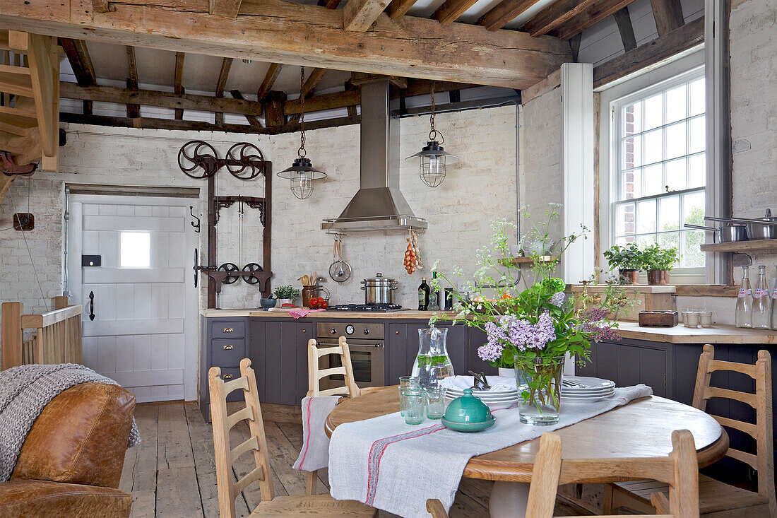 Tisch und Stühle im Stil des Kunsthandwerks in der offenen Küche einer denkmalgeschützten Windmühle (Kent, UK)
