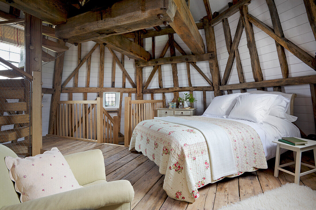 Doppelbett und Holzbalken in einer denkmalgeschützten Windmühle, Kent, Großbritannien