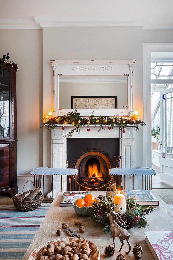 Beleuchtetes Feuer und Glasvitrine mit Weihnachtsdekoration im Warehorne Pfarrhaus in Kent UK