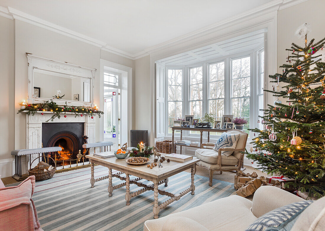 Weihnachtsbaum und Girlande im Wohnzimmer des Warehorne Pfarrhauses von 1820 mit beleuchtetem Kamin Kent UK