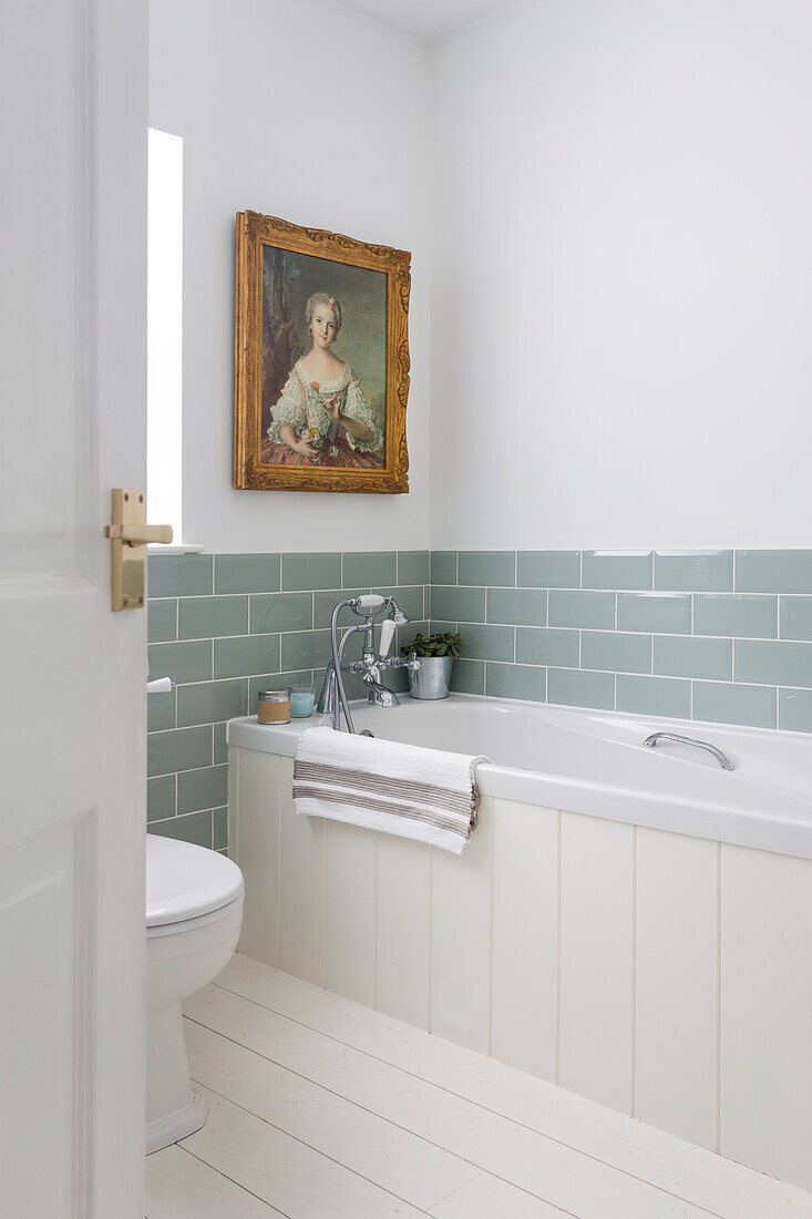 Antique portrait with sage green metro tiles in bathroom Southsea UK