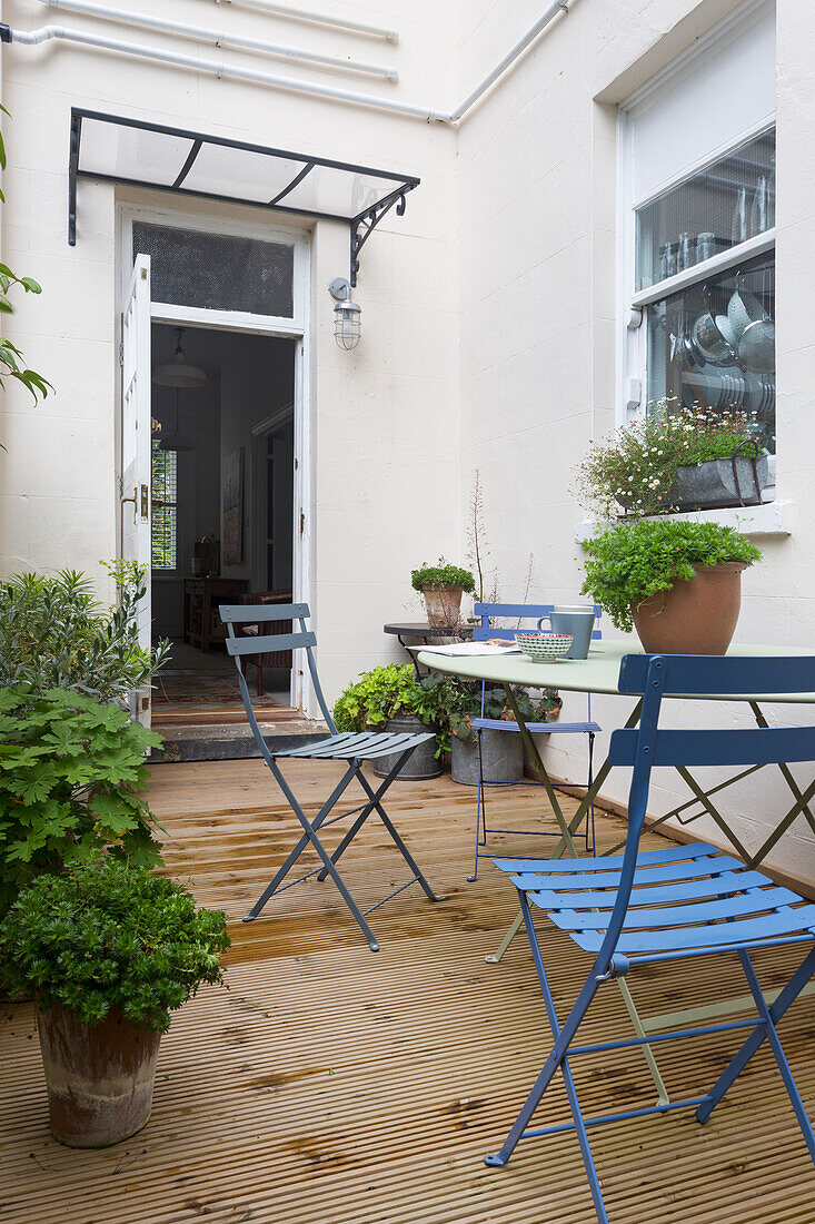 Blue folding chairs on decking of Southsea home UK