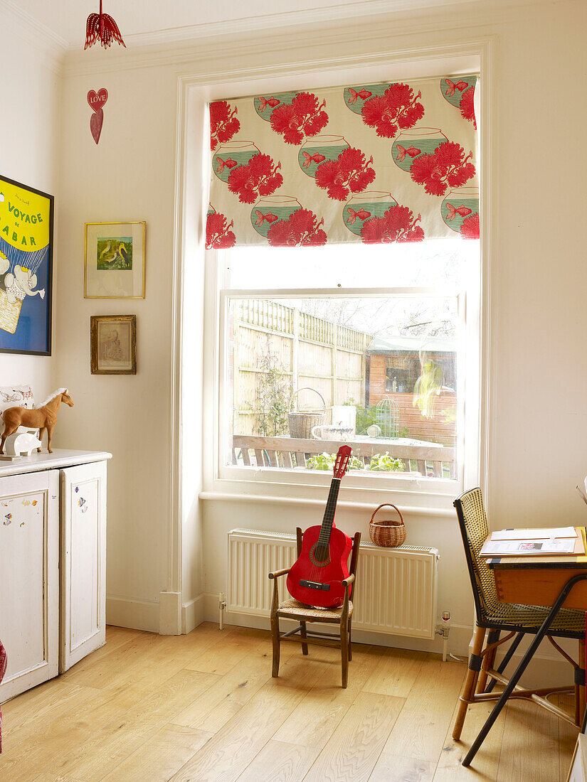 Gemustertes Rollo am Fenster mit Gitarre im Kinderzimmer eines Londoner Familienhauses, England, UK